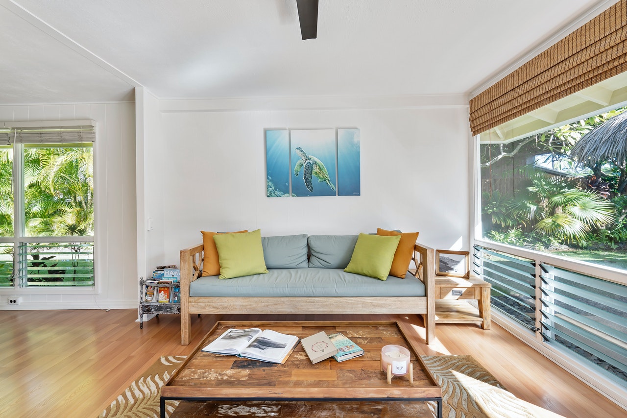 the living room with a low sofa, a coffee table, and two windows