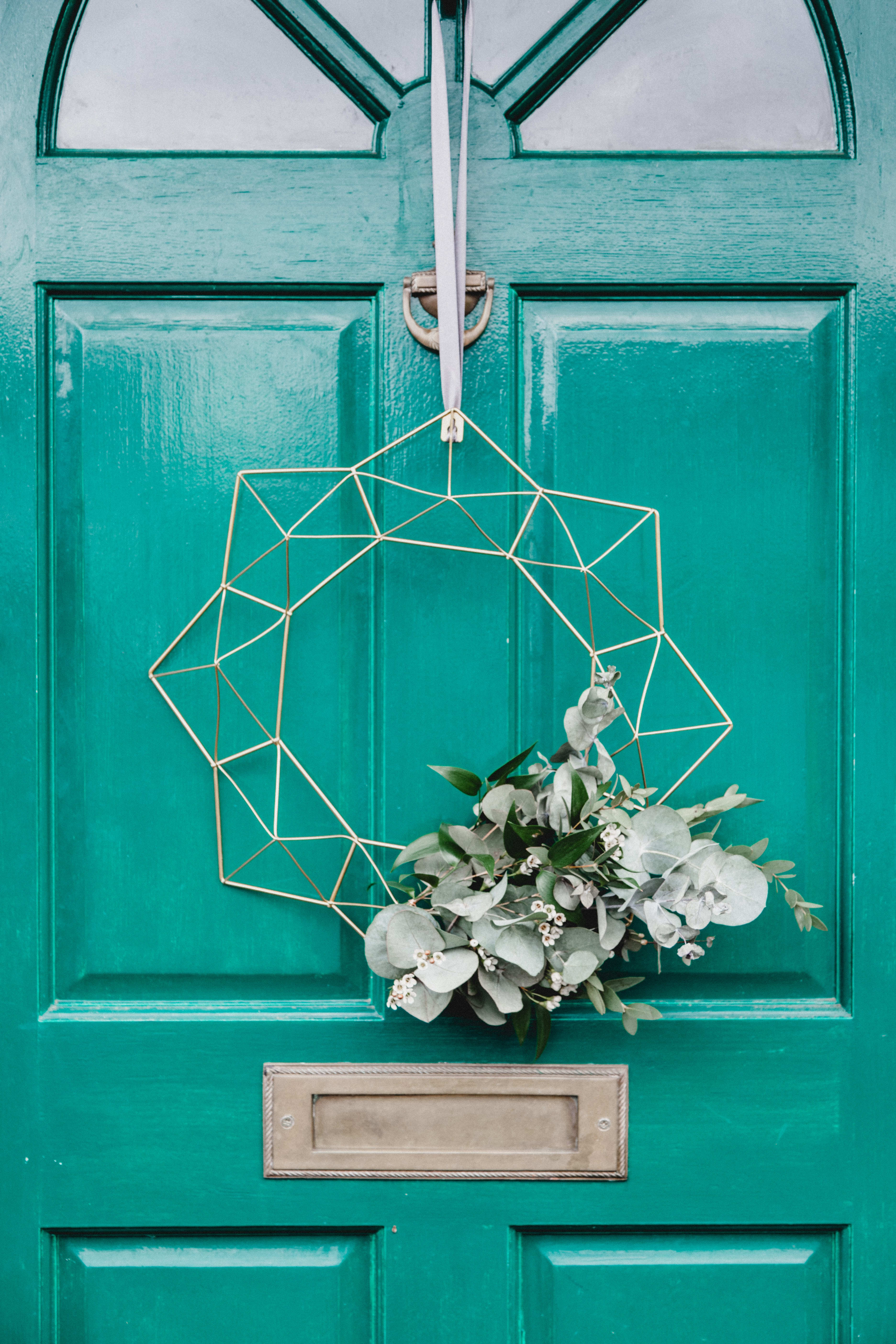 teal front door with seasonal wreath 